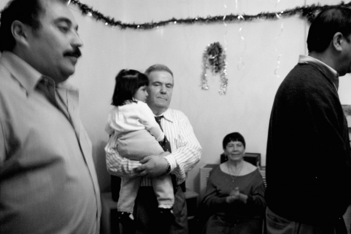 Neighbor holding one of his friend's children at his home in Downtown Los Angeles.