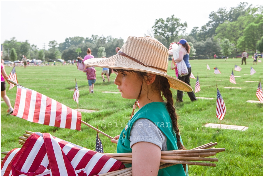 Girl Scouts placing American flags on graves on military for Memorial Day at Brigadier General Doyle Cemetary 