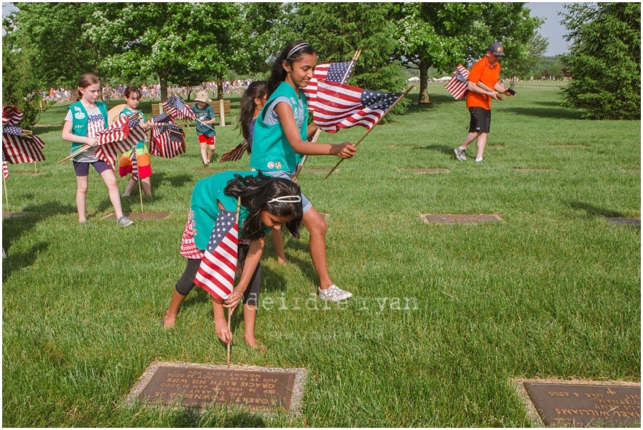 Girl Scouts placing American flags on graves on military for Memorial Day at Brigadier General Doyle Cemetary 