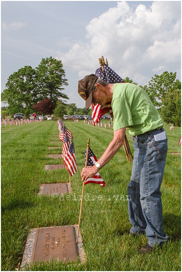 Girl Scouts placing American flags on graves on military for Memorial Day at Brigadier General Doyle Cemetary 