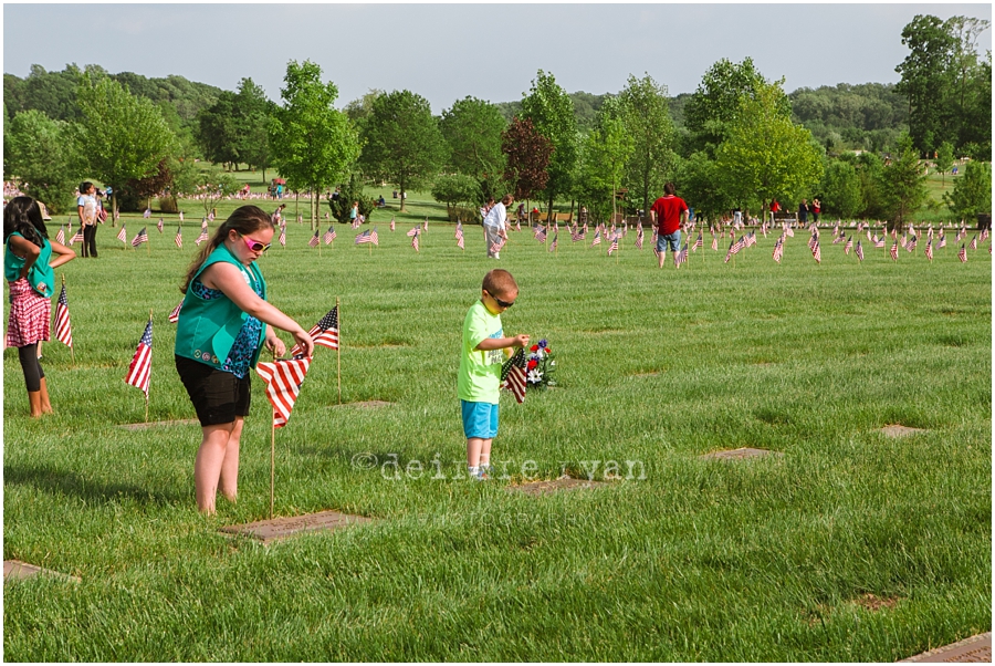 Girl Scouts placing American flags on graves on military for Memorial Day at Brigadier General Doyle Cemetary 