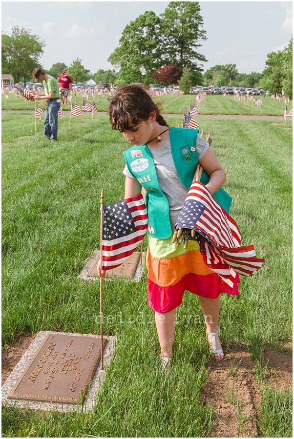 Girl Scouts placing American flags on graves on military for Memorial Day at Brigadier General Doyle Cemetary 