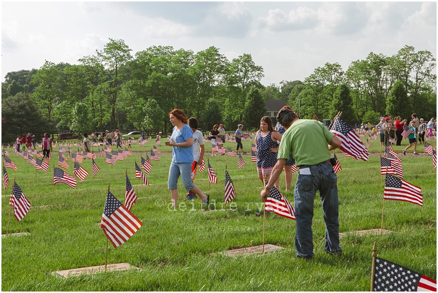 Girl Scouts placing American flags on graves on military for Memorial Day at Brigadier General Doyle Cemetary 