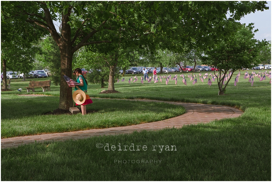 Girl Scouts placing American flags on graves on military for Memorial Day at Brigadier General Doyle Cemetary 