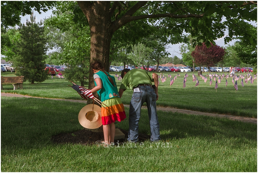 Girl Scouts placing American flags on graves on military for Memorial Day at Brigadier General Doyle Cemetary 