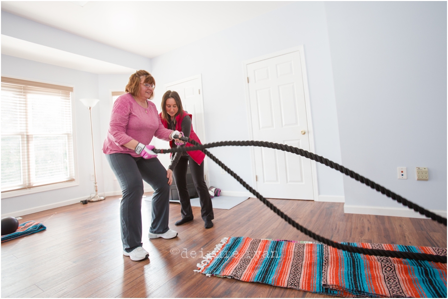 The owner of Wholetrition helps to train a client using the heavy ropes as part of her workout routine.