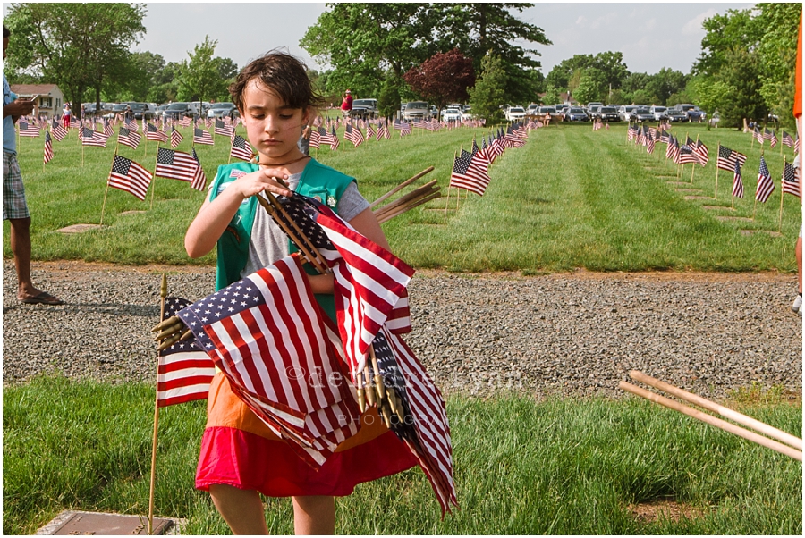 Girl Scouts placing American flags on graves on military for Memorial Day at Brigadier General Doyle Cemetary 